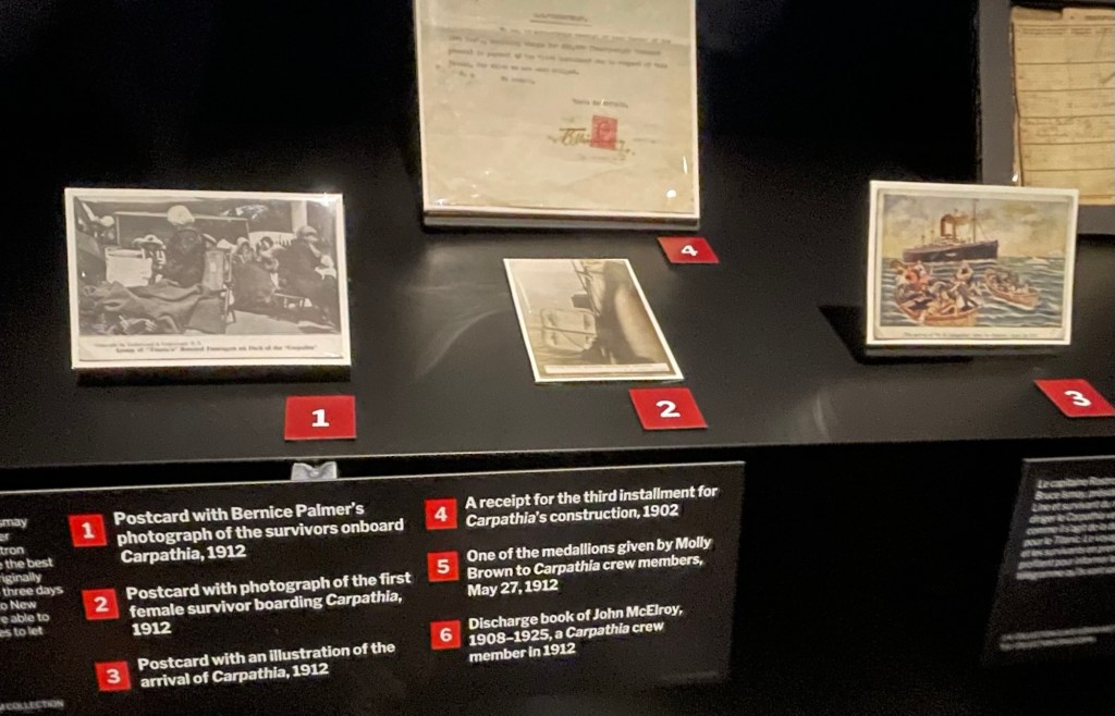 Display shows 4 items. 1 Postcard with Bernice Palmer's photograph of the survivors onboard
Carpathia, 1912, a crowded scene of women on deck chairs 2 Postcard with photograph of the first female survivor boarding Carpathia, as viewed from alongside Carpathia 1912
3 Postcard with an illustration of the arrival of Carpathia, as viewed from Titanic’s lifeboats with 2 other lifeboats in view 1912
4 Bottom of a receipt for the third installment for Carpathia's construction, 1902
