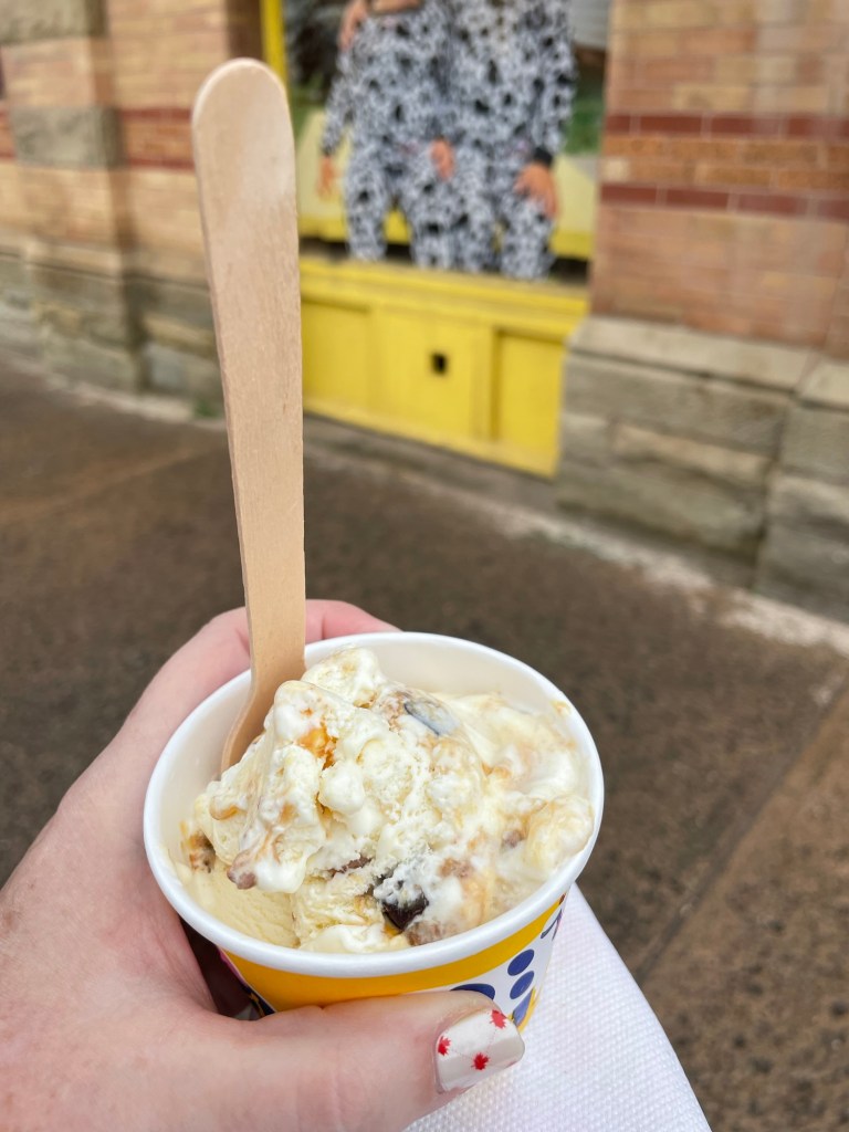 A scoop of vanilla ice cream with chocolate and caramel bits